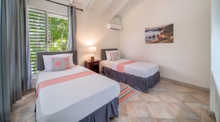 Twin bedroom at 149 Salters Road with coral runners and a louvred window, Barbados