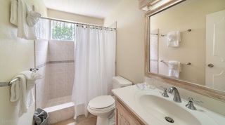 Bathroom with curtained tiled shower and vanity at 149 Salters Road villa, Barbados