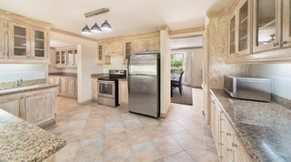 Fitted kitchen with limed-wood cabinets and granite worktops at 149 Salters Road, Barbados