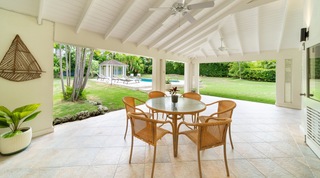 Covered terrace dining table looking out to the lawn and pool at 149 Salters Road villa, Barbados