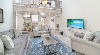 149 Salters Road in Barbados, double-height living room with mezzanine gallery and blue patterned rug
