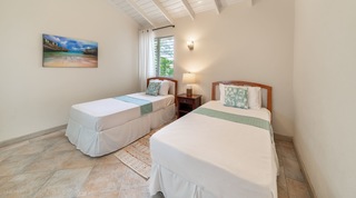 Twin room with vaulted beamed ceiling and beach artwork at 149 Salters Road, St. James, Barbados