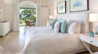 En-suite king bedroom with teal accents opening to the garden at Bananaquit, St. James, Barbados