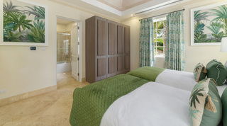 Tropical palm prints flanking a tall panelled wardrobe at Bella Vista villa, Barbados