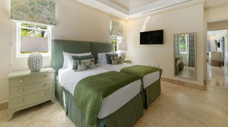Green twin bedroom with a brass-handled chest and wall-mounted television, Bella Vista, Barbados