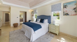 Navy quilted throw and beach paintings in a bedroom at Bella Vista, Royal Westmoreland villa, Barbados