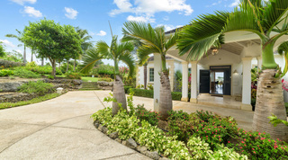Columned entrance porch framed by palms and flowering beds at Bella Vista, Barbados
