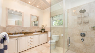 Twin basins and paired limed wood mirrors in a bathroom at Carlton Ridge villa rental, Barbados