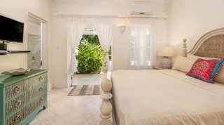 Woven seagrass headboard and a green painted chest of drawers at Carlton Ridge, Barbados