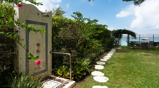 Outdoor garden shower in rendered plaster with mosaic tiling and hibiscus at Church Point 2, Barbados