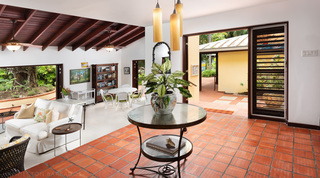 Open-plan sitting room with terracotta floor and glass-topped table at Church Point 2 villa, Barbados