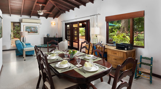 Dining room with a polished dark-wood table set for dinner at Church Point 2 villa rental, Barbados