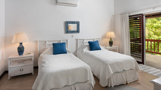 Twin bedroom with blue cushions and a door to the terrace at Church Point 2, Holetown, Barbados