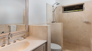 Bathroom with a stone-tiled walk-in shower and chrome fittings at Church Point 2, Holetown, Barbados