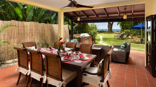 Covered terrace set for al fresco dining with garden and sea beyond at Church Point 2, Holetown, Barbados