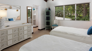 Twin bedroom with a white dresser and dressing area beyond at Church Point 2 villa, Barbados