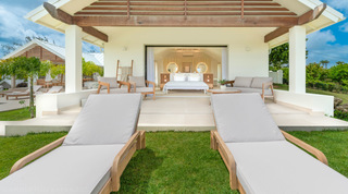 Primary bedroom pavilion opening to a garden lawn with sun loungers at Cloudbreak, St. James villas, Barbados