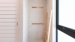 Tiled recess with twin brass rails and a bamboo ladder beside a frosted window at Cloudbreak villa, Barbados