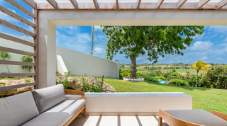 Bedroom terrace with teak seating framing rolling countryside and ridge views at Cloudbreak villa, Barbados