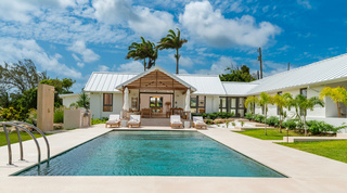 Cloudbreak, a holiday villa in Barbados, with its private pool, gabled terrace and sun loungers under palms