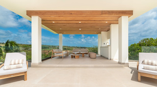 Covered terrace lounge with a wet bar looking out over rolling countryside at Cloudbreak villa, Barbados