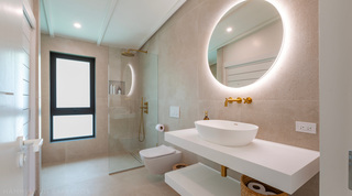 En-suite with a vessel basin, brass taps and a walk-in rainfall shower in tiled stone at Cloudbreak, Barbados