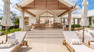 Teak sun loungers on the pool deck facing the gabled terrace pavilion at Cloudbreak villa, St. James, Barbados
