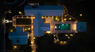 Overhead night view onto the metal roofs, courtyard gardens and lit pool of Cloudbreak, Barbados