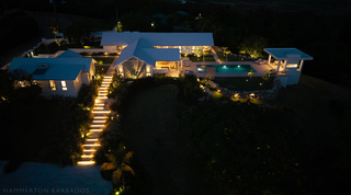 Night aerial of the illuminated steps, terraces and pool at Cloudbreak, luxury villa in Barbados