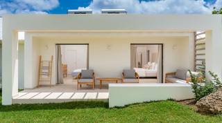 Two-bedroom guest cottage opening to a shared terrace with teak seating at Cloudbreak, Westmoreland, Barbados