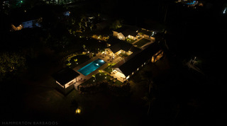 Cloudbreak from above after nightfall, its pool, terraces and gazebo glowing against the dark countryside, Barbados