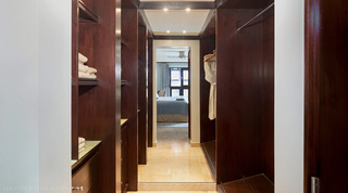 Walk-in wardrobe with folded towels, drawers and a bathrobe on the hanging rail at Coral Cove 14 – Crowsnest in Barbados