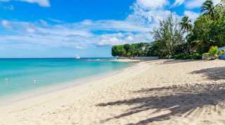 Quiet curve of white sand along the west coast near Coral Cove 14 – Crowsnest in Barbados, a motor yacht offshore