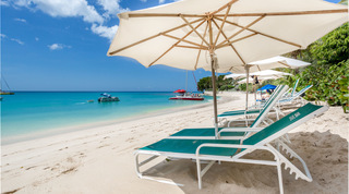 Cream parasol over green loungers and a red catamaran close inshore on Paynes Bay, Coral Cove 14 – Crowsnest in Barbados