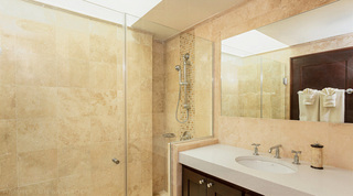 Glass shower with a mosaic strip and single-basin vanity in a stone-tiled bathroom at Coral Cove 14 – Crowsnest, Barbados