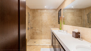 Double vanity, frameless glass shower and a bundle of tall grasses in a bathroom at Coral Cove 14 – Crowsnest in Barbados