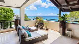 Wicker daybeds, teal cushions and an ice bucket in a terrace corner, Coral Cove 14 – Crowsnest holiday apartment, Barbados