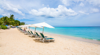 Long row of white parasols over green loungers, swim buoys offshore, at Coral Cove 14 – Crowsnest, Barbados apartment rental