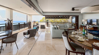 Open-plan living and dining flowing onto the covered sea-view terrace of the Coral Cove 14 – Crowsnest penthouse in Barbados