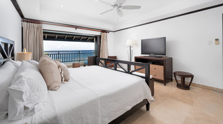 Master bedroom with king bed opening to a sea-view terrace at Coral Cove 15 - Penthouse, luxury apartment Barbados