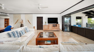 Open-plan living room with white sofas opening to the terrace at Coral Cove 15 - Penthouse, Barbados