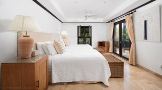 Bright bedroom with king bed and French doors to a garden terrace at Coral Cove 15 - Penthouse, Barbados