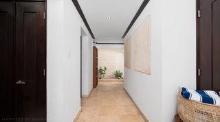 Travertine entrance hallway with artwork and planted feature at Coral Cove 15 - Penthouse, Barbados