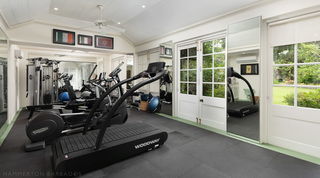 Mirror-walled gym with a slat-belt treadmill and cable weight machine over gym matting, Crystal Springs, Barbados