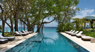 Turquoise mosaic infinity pool reaching the sea, loungers under mature trees, Crystal Springs villa, Barbados