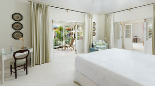 Bedroom with striped curtains, a writing desk and doors to a garden verandah, Crystal Springs villa, Barbados