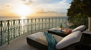 Sun loungers and glasses of wine on a curving sea-view balcony at sunset, Crystal Springs villa, Barbados