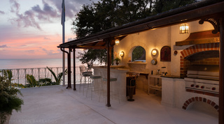 Crystal Springs' outdoor bar and brick-arched barbecue above the sea as the light fades, Barbados