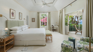 Bedroom with a scalloped green headboard and doors to a sea-view verandah, Crystal Springs villa, Barbados