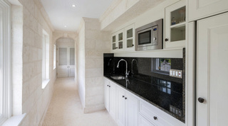 Prep pantry with coral-stone walls and dark granite counter at Four Winds in Gibbs, Barbados